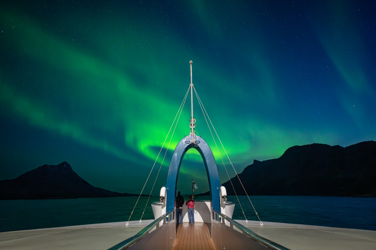 A boat with a green aurora borealis in the background

Description automatically generated